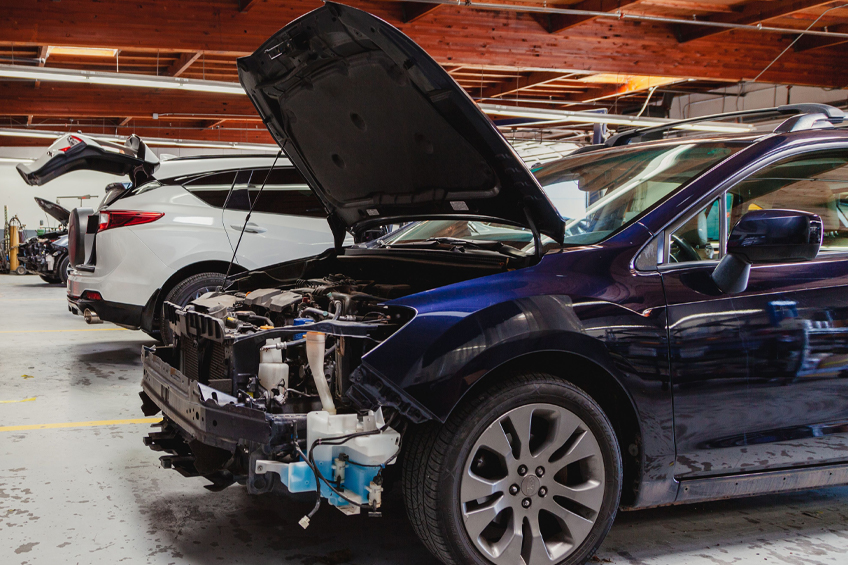 collision Auto body repairs. Mechanic worker burnish and polishing automobile car body by buffing grinding machine in garage workshop. Toned